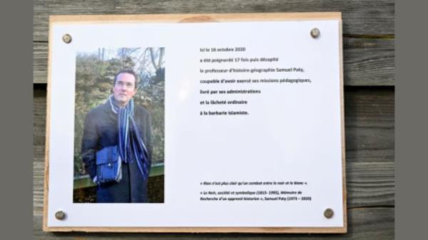 A photograph taken on October 16, 2023 shows a commemorative plaque for slain teacher Samuel Paty (portrait) near the Bois d&#039;Aulne school in Conflans-Sainte-Honorine, outside Paris. BERTRAND GUAY/Pool via REUTERS
